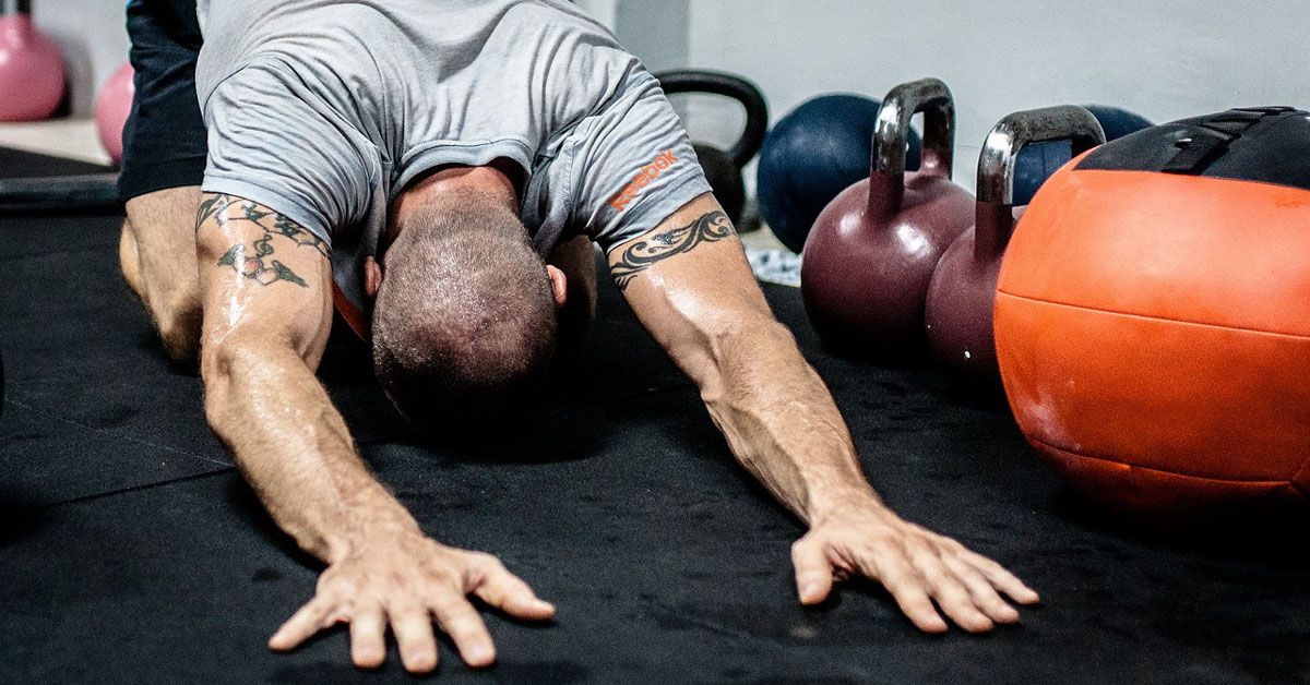 Man Stretching Beside Kettlebell